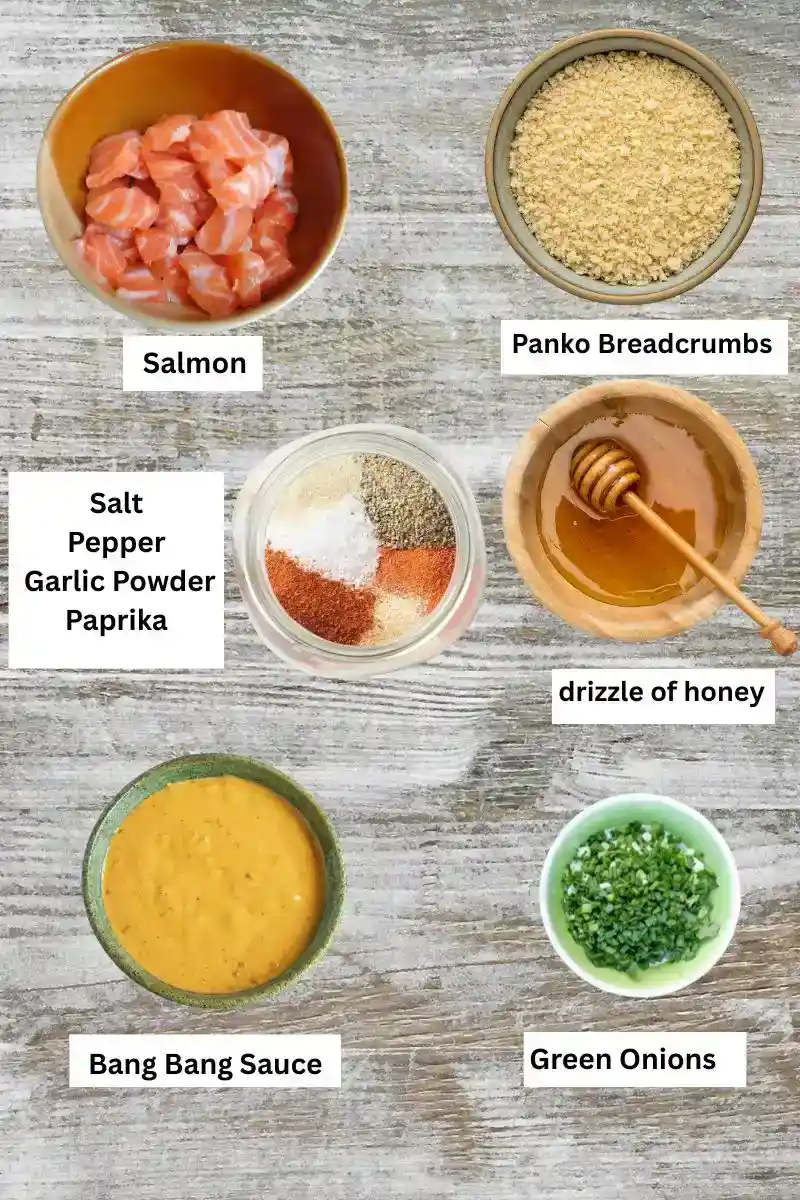 Bang Bang Salmon Bites ingredients including diced salmon, panko breadcrumbs, seasonings (salt, pepper, garlic powder, paprika), honey, bang bang sauce, and chopped green onions 