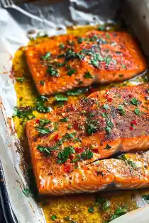 Baked salmon fillets topped with brown sugar spice rub and parsley in a pan